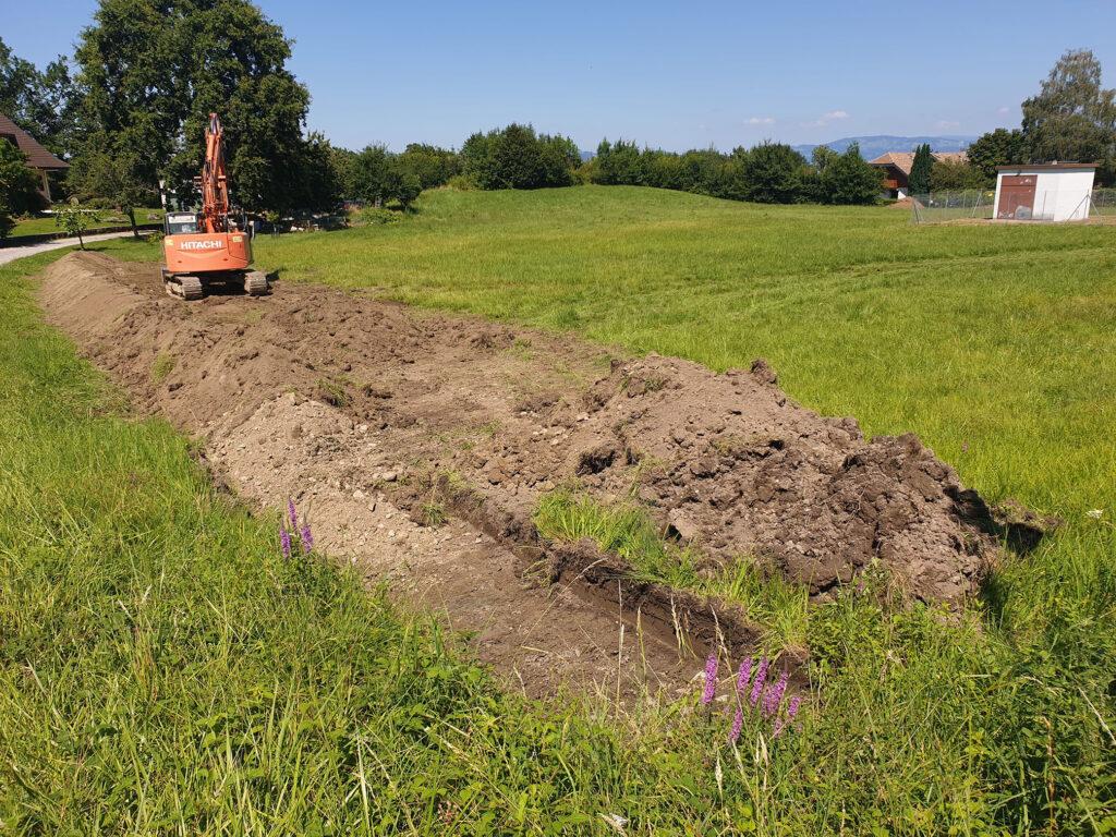 Pelleteuse creusant pour un chantier de travaux d'électricité et de gaz