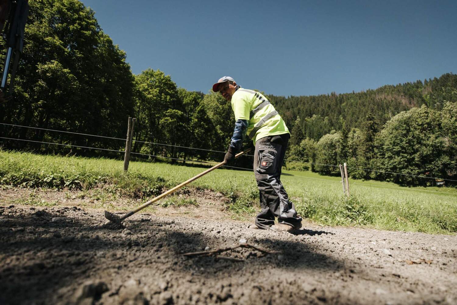 Photo d'un ouvrier entrain de ratisser de la terre