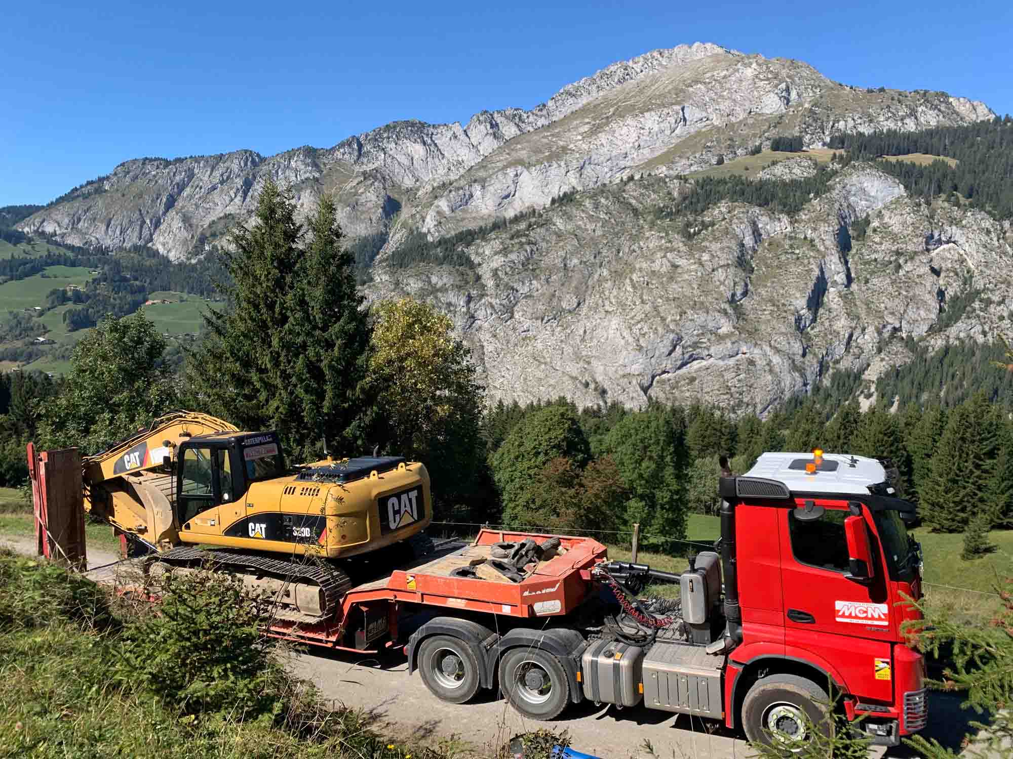 Photo d'un camion MCM TP entrain de déplacer une pelleteuse sur remorque