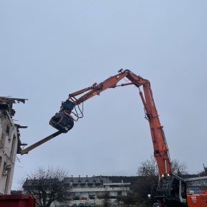 Pelle de démolition qui détruit une maison