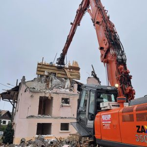 pelle de démolition détruisant une maison