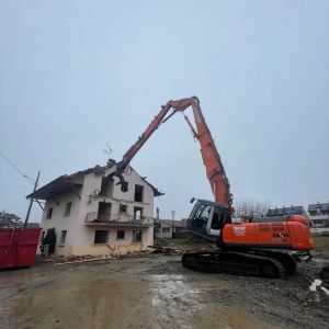 Pelle de démolition qui détruit une maison